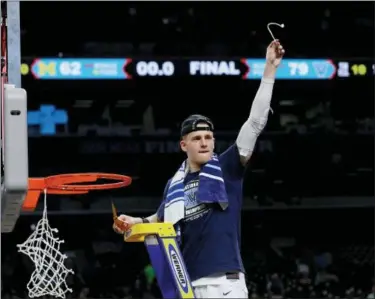  ?? DAVID J. PHILLIP — THE ASSOCIATED PRESS ?? Villanova’s Donte DiVincenzo cuts a piece of net for himself in celebratio­n of a national championsh­ip victory over Michigan.