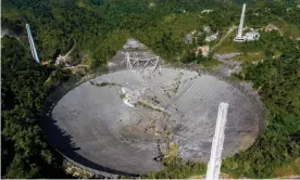  ?? Photograph: Ricardo Arduengo/AFP/ Getty Images ?? The ruined Arecibo radio telescope after cables supporting its suspended instrument platform broke, sending it crashing down into the disc.