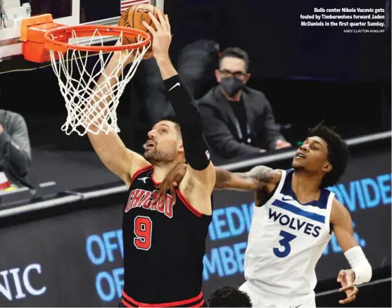  ?? ANDY CLAYTON-KING/AP ?? Bulls center Nikola Vucevic gets fouled by Timberwolv­es forward Jaden McDaniels in the first quarter Sunday.