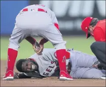  ?? MIKE CARLSON – THE ASSOCIATED PRESS ?? Angels manager Joe Maddon leans over to check on Dexter Fowler, who was injured during a play at second base against Toronto on Friday night.