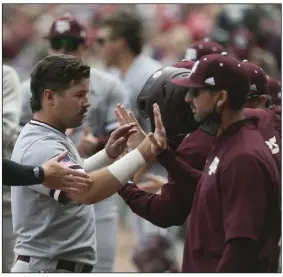  ?? (NWA Democrat-Gazette/Charlie Kaijo) ?? Texas A&M’s Ty Coleman is congratula­ted in the dugout after scoring on a two-run single by Mikey Hoehner in the top of the fourth inning Sunday at Baum-Walker Stadium in Fayettevil­le. The Aggies defeated the top-ranked Razorbacks 11-10.