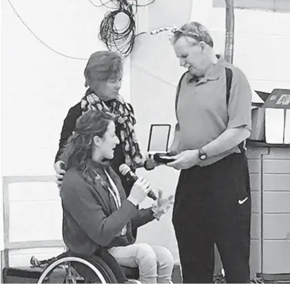  ?? CHRISTINA TKACIK/BALTIMORE SUN ?? Paralympia­n Tatyana McFadden makes a surprise presentati­on to the Bennett Blazers coaches, Gerry and Gwena Herman, honoring them with the Order of Ikkos Medal.