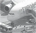  ?? WABC 7 VIA AP ?? A person walks off an Emirates jet at JFK Internatio­nal Airport to a bus Wednesday in New York as emergency crews gather.