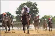  ?? Seth Wenig / Associated Press ?? Tiz the Law, center, crosses the finish line to win the Belmont Stakes.