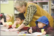  ??  ?? June Murray, a volunteer at the Community Creative Center at the Walton Arts Center’s Nadine Baum Studios, leans over to assist Corey Thompson, a pre-kindergart­en student from Decatur, on his frog coloring project.
(NWA Democrat-Gazette/David Gottschalk)