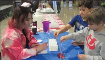  ?? Photos by Heather Cameron ?? Peyton Brownlee, age 9 (left); and Parker Brown, age 8 (right) make a rainbow in a glass while a volunteer watches carefully.