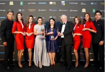  ??  ?? Suhaila (fourth left) and Audrey (centre) accept the World’s Leading Low-Cost Airline and World’s Leading Low-Cost Airline Cabin Crew awards from WTA president and founder Graham Cooke (fourth right), flanked by AirAsia cabin crew.