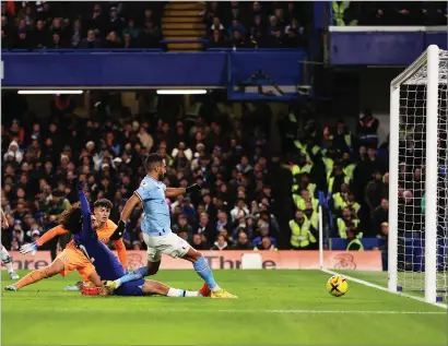  ?? ?? Riyad Mahrez strikes to put Manchester City ahead at Stamford Bridge, and below his team- mates celebrate