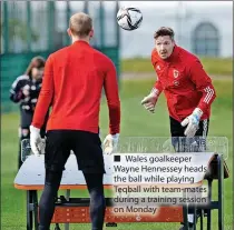  ?? ?? ■ Wales goalkeeper Wayne Hennessey heads the ball while playing Teqball with team-mates during a training session on Monday