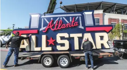  ?? AP ?? Workers load an All-Star sign onto a trailer after it was removed from Truist Park in Atlanta last Tuesday.