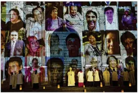  ?? ASSOCIATED PRESS ?? The Archbishop of Lima, Carlos Castillo (center) swings a censer near portraits of COVID-19 victims projected on the facade of Lima’s cathedral during a Mass dedicated to the more than 30,000 deceased in Peru due to the coronaviru­s.