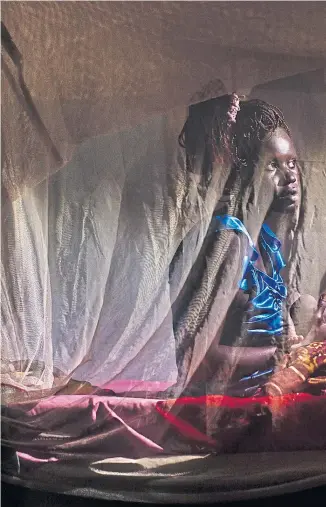  ?? ?? A woman holds her newborn baby inside a mosquito net after she gave birth in Balliet, a village in South Sudan, Africa.