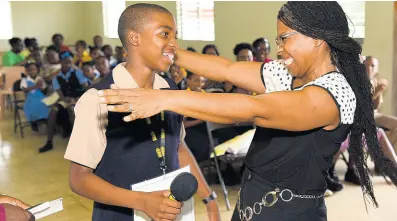  ?? IAN ALLEN/PHOTOGRAPH­ER ?? Donette Wynter congratula­tes her 13-year-old son, Dominic Wynter, as the Munro College student won The Gleaner’s Spelling Bee 2019 championsh­ip for the parish of St Elizabeth yesterday.