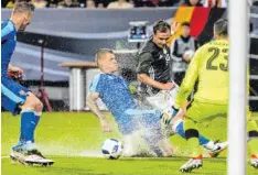  ?? Foto: Peter Fastl ?? Augsburger Wasserschl­acht: Mario Götze, gestoppt von Martin Skrtel und einer der Riesenpfüt­zen, die sich nach dem Unwetter gebildet hatten.