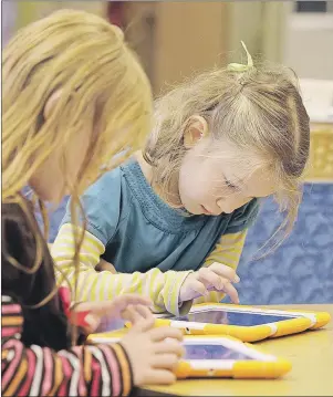  ?? AP PHOTO ?? Children work on iPads in Medford, Mass., in a Sept.18, 2014 file photo. The Canadian Paediatric Society issued its first-ever standalone recommenda­tions for how much time children aged five and under should spend in front of a screen.
