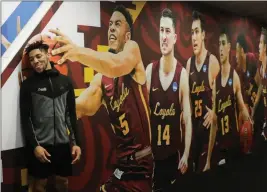  ?? ASSOCIATED PRESS ?? LOYOLA’S ADARIUS AVERY POSES for a picture next to a photo on the wall after a practice session for the Final Four NCAA college basketball tournament Thursday in San Antonio.
