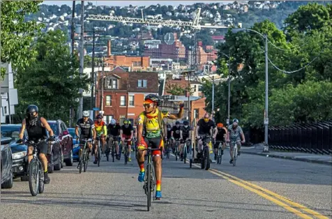  ?? Alexandra Wimley/Post-Gazette ?? Shequaya Bailey, president of the Pittsburgh Major Taylor Cycle Club, raises her fist in the air Tuesday as she and hundreds of other cyclists ride up Crawford Street to Freedom Corner in the Hill District, where the group paused for brief speeches and chants, during a silent bike ride to remember George Floyd, Ahmaud Arbery and Breonna Taylor.