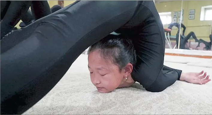  ??  ?? Suvd-Erdene, 9, is training to be a contortion­ist. It may look hard, but because of their training young children are able to twist their bodies like this.