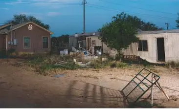  ?? CHRISTOPHE­R LEE/THE NEW YORK TIMES ?? The trailer at right in Carrizo Springs, Texas, was where smugglers held hundreds of migrants hostage, torturing and raping some of them in an effort to squeeze their families for more money, according to officials.