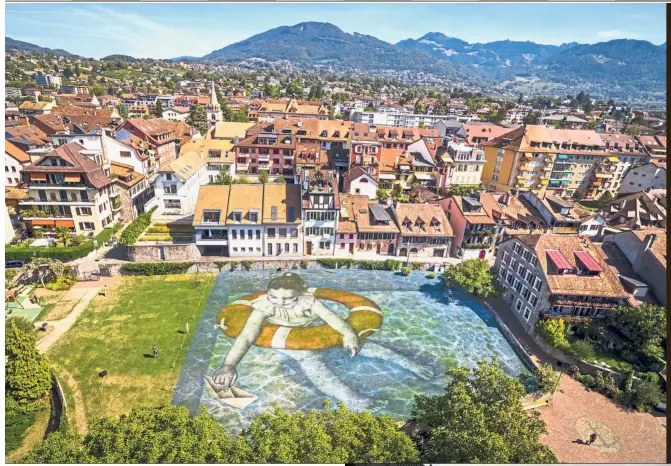  ?? AP ?? A giant landart painting titled ‘ Which Legacy?’ by French artist Saype, depicting a young girl wearing a lifebuoy, is pictured on a patch of grass in La Tour- de-Peilz near Vevey in Switzerlan­d. The artwork covering almost 2,000sq m, produced with biodegrada­ble paint, is part of the Vevey ‘Festival Images’ visual arts held in Vevey city between Sept 8 and 30. — Picture perfect