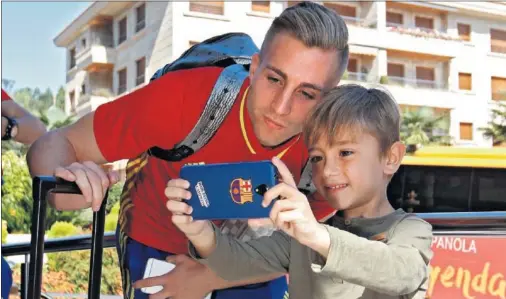  ??  ?? CON LA SUB-21. Gerard Deulofeu atiende a un joven seguidor del Barcelona que le pidió hacerse una foto con él.