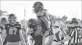  ?? RICHARD SHIRO/AP ?? Coastal Carolina's Reese White, right, is lifted by Willie Lampkin after scoring Saturday.