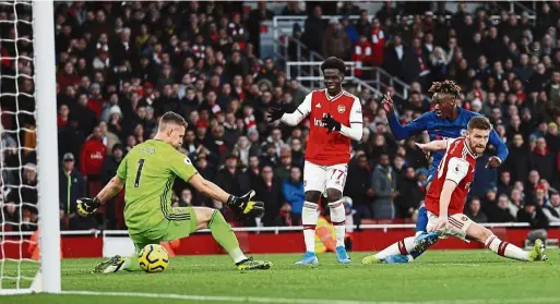  ?? — AP/AFP ?? Bang on target: Tammy abraham scoring chelsea’s second goal against arsenal at the emirates on sunday. Top: a combinatio­n shot shows arsenal’s Pierre-emerick aubameyang celebratin­g his goal.