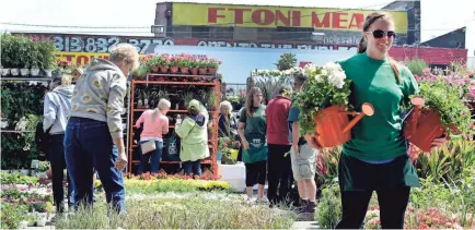  ?? DIANE WEISS/DETROIT FREE PRESS ?? Natalie Ravenscrof­t works at the 48th Annual Flower Day at Eastern Market in Detroit in 2014. More than 200,00 people attend annually.