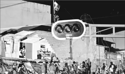  ??  ?? A Mexican marine places the national flag over a collapsed building as rescue workers continue to search for survivors as night falls in Mexico City, three days after the powerful quake that hit central Mexico, causing panic among the megalopoli­s’ 20 million inhabitant­s on the 32nd anniversar­y of a devastatin­g 1985 quake. — AFP photo