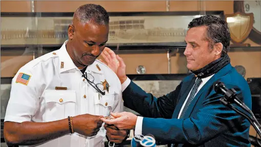  ?? KYLE TELECHAN/POST-TRIBUNE ?? Hammond Mayor Thomas McDermott Jr., right, hands a new badge to newly appointed Hammond Police Chief William Short on Friday.