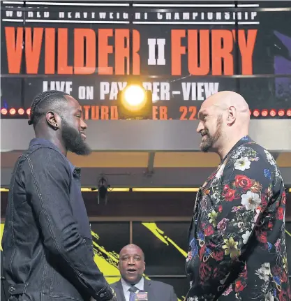  ??  ?? Deontay Wilder, left, and Tyson Fury face off during a news conference in Los Angeles last month.