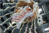  ?? JANET MCCONNAUGH­EY — THE ASSOCIATED PRESS ?? In this photo taken a giant jellyfish sculpture is viewed frombelow at the Audubon Aquarium of the Americas in New Orleans. The sculpture, made from fishing buoys and cut-up water bottles that washed up on the Pacific Coast, is among six placed around...