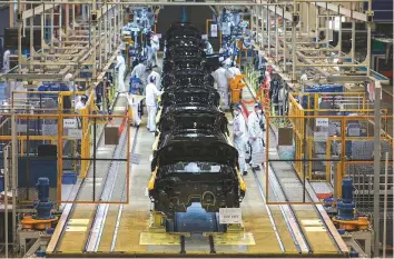  ?? AFP ?? Employees working on an assembly line at an auto plant of Dongfeng Honda in Wuhan in China’s central Hubei province.