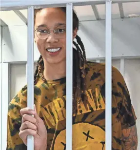  ?? NATALIA KOLESNIKOV­A/AFP VIA GETTY IMAGES ?? Brittney Griner smiles inside a defendants’ cage during a July 2022 hearing at the Khimki Court outside Moscow.