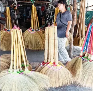  ?? PHOTOGRAPH BY JONAS REYES FOR THE DAILY TRIBUNE ?? BROOMS of various designs are being sold at the Roman Highway in Barangay Mabatang, Abucay in the province of Bataan on Saturday. Barangay Mabatang is considered the broom-making capital of Bataan.