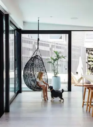  ??  ?? ABOVE LEFT Next to a hanging chair from Dawson & Co, an electric window by Schugg opens the kitchen’s side wall. Dylan extended the pool into the corner here, so the ripples can reflect onto the roof. “It makes us feel really connected to the outdoors,” says Kelly. “I love looking out at the water, it’s just so peaceful.” ABOVE RIGHT
Also designed by Robyn, the laundry features many of the same elements as the kitchen, including Buddy tapware by Progetto from Plumbline (used throughout the house in Aged Iron and Brushed Brass finishes) and a sink by Oliveri. The Antilia tiles are from Artedomus.