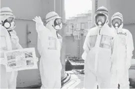  ?? AFP/Getty Images/File ?? Japanese Prime Minister Shinzo Abe, second from right, tours the damaged Fukushima nuclear facility. Vietnam is pressing ahead with plans for plants, despite safety fears.