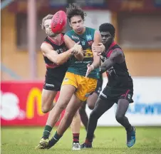  ??  ?? St Mary's player Braxton Ah Mat is tackled by Tiwi Bombers Joshua Finch and Pio Puautjimi