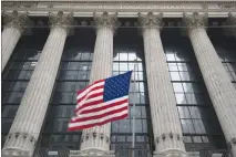  ?? MARY ALTAFFER / AP ?? An American f lag f lies outside the New York Stock Exchange. A big topic on Wall Street has been the so-called yield curve, the difference between interest rates on short-term U.S. government bonds and longterm government bonds. The curve is...