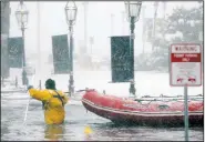  ?? AP/MICHAEL DWYER ?? A Boston firefighte­r wades through floodwater from Boston Harbor on Long Wharf on Thursday in Boston.