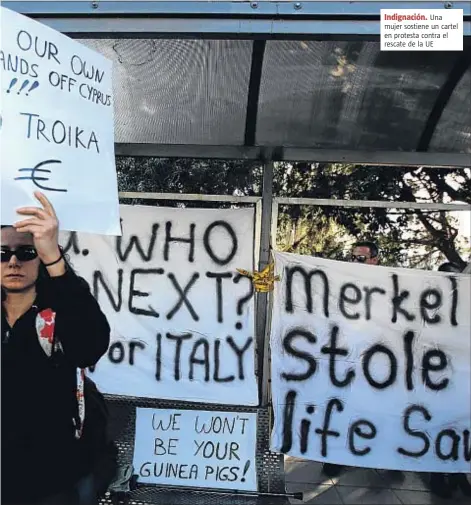  ?? PATRICK BAZ / AFP ?? Indignació­n. Una mujer sostiene un cartel en protesta contra el rescate de la UE