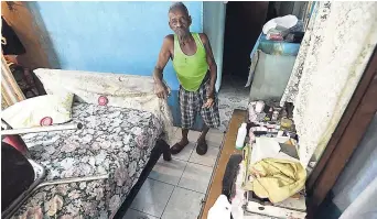  ?? RICARDO MAKYN ?? Milford Mills stands in his bedroom, where he says he was attacked by an evil spirit that threw his belongings all over the room on Sunday.