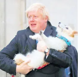  ?? AP ?? Britain’s Prime Minister and Conservati­ve Party leader Boris Johnson holds his dog, Dilyn, as he leaves after voting in the general election at Methodist Central Hall, Westminste­r, London, yesterday.