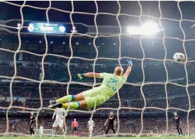  ?? AFP ?? Napoli’s goalkeeper from Spain Pepe Reina dives for the ball as Real Madrid’s Brazilian midfielder Casemiro scores a goal during the UEFA Champions League Round of 16 first leg football match at the Santiago Bernabeu stadium in Madrid. Real won 3-1. —