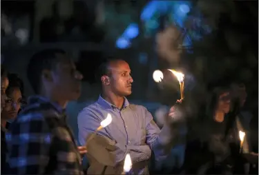  ?? MULUGETA AYENE — THE ASSOCIATED PRESS ?? Colleagues and relatives light candles in tribute at a memorial service for the crew of Ethiopian Airlines Flight ET302, held at the Ethiopian Pilots Associatio­n in the capital Addis Ababa March 10in Ethiopia. Relatives and colleagues gathered Tuesday to remember those who died one year ago when the jet crashed killing all 157 on board.