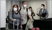  ?? NAM Y. HUH — ASSOCIATED PRESS ?? Travelers wear protective mask as they walk through a terminal at O’Hare Internatio­nal Airport in Chicago on Sunday, March 1, 2020.
