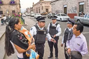  ?? BRETT GUNDLOCK FOR THE NEW YORK TIMES ?? Community policing has been welcomed by residents in Morelia, Mexico. In other cities, the police are feared. Providing directions.