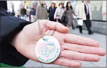  ??  ?? A woman holds a maternity mark on a street in Tokyo on March 3, 2016. Harassment of working mothers is a growing problem in Japan, possibly aggravated by government policies aimed at keeping women in the workforce, experts say.