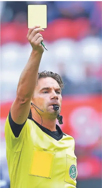  ?? FOTO: DPA ?? So kennt man den Polizisten aus Nütterden seit Jahrzehnte­n: Schiedsric­hter Guido Winkmann zeigt die gelbe Karte – in diesem Fall bei einem Match am Kaiserslau­terner Betzenberg.