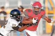  ?? THE OKLAHOMAN] [PHOTO BY SARAH PHIPPS, ?? Carl Albert’s Dadrion Taylor tries to escape the tackle of Midwest City’s Emmitt McClendon in Friday’s game. Taylor injured his knee near the end of the game and will miss this week’s contest against Del City.